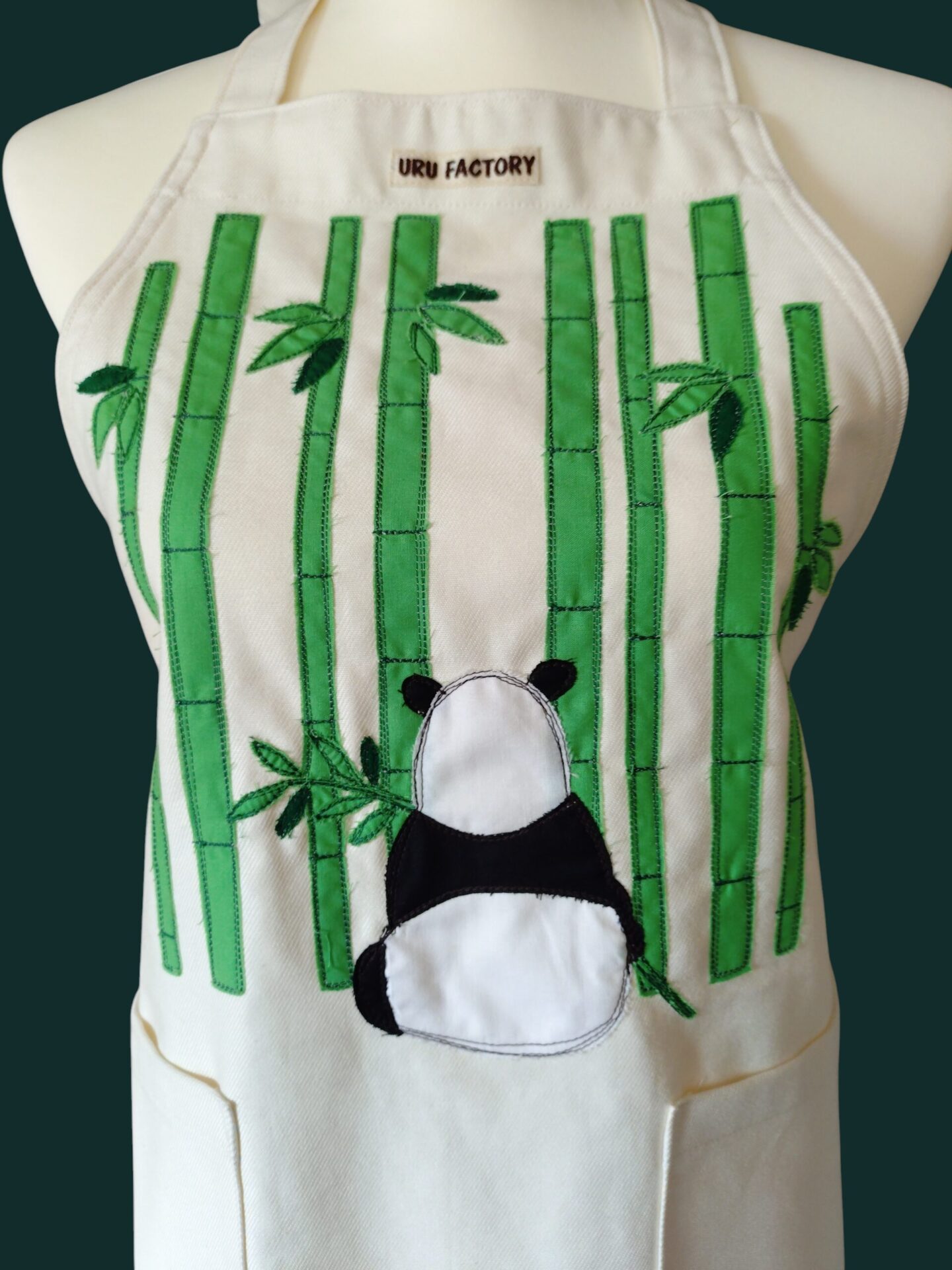 エプロンに縫われた竹とパンダのアップリケの正面拡大画像