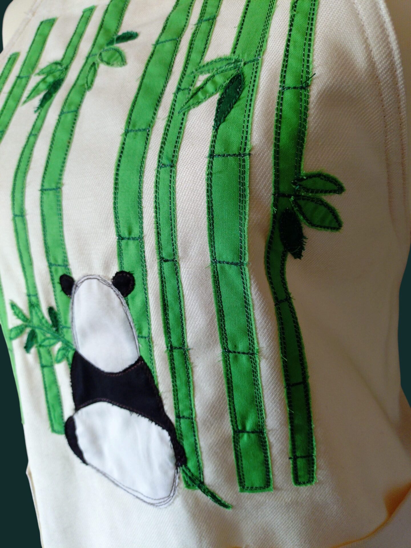 エプロンに縫われた竹とパンダのアップリケの拡大画像