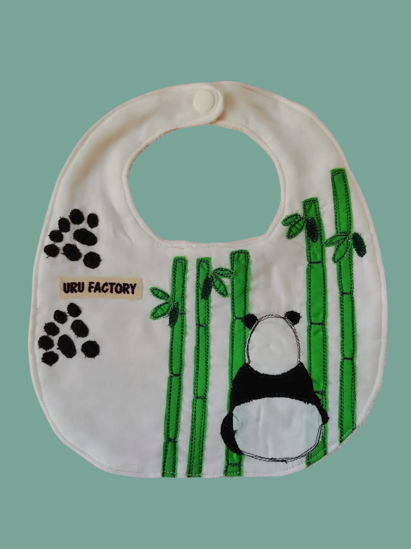 竹とパンダの後ろ姿のアップリケがつけられたベビースタイ