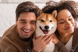 柴犬に両サイドから頬ずりする男女
